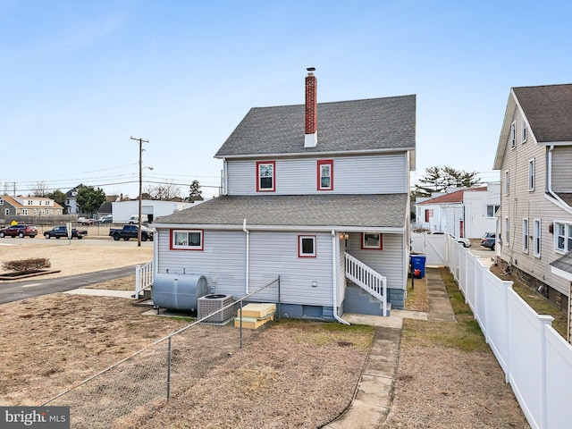 rear view of house featuring central air condition unit