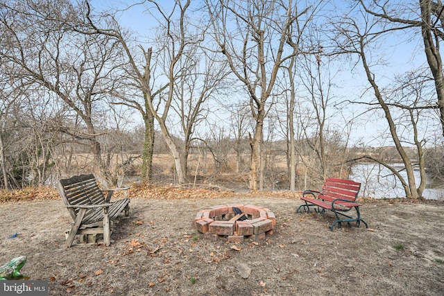 view of yard with a water view and an outdoor fire pit