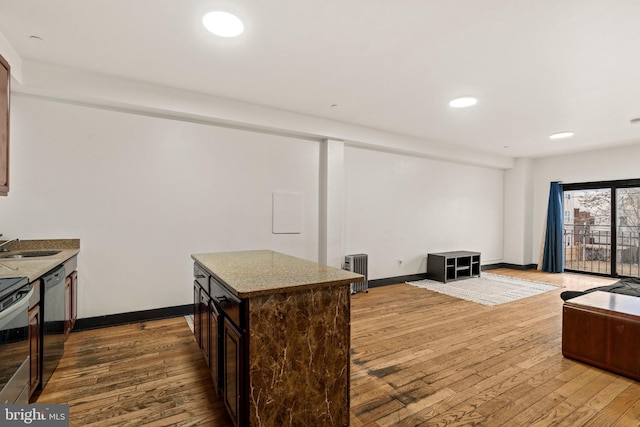 kitchen with dark brown cabinetry, radiator heating unit, dishwasher, and wood-type flooring