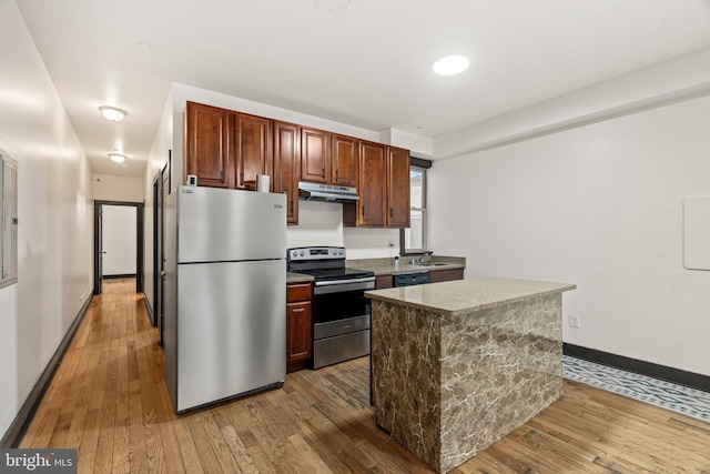 kitchen featuring hardwood / wood-style flooring, appliances with stainless steel finishes, a center island, and sink