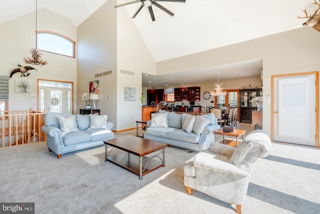 carpeted living room featuring ceiling fan with notable chandelier