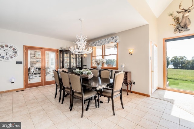 tiled dining space with a notable chandelier and french doors