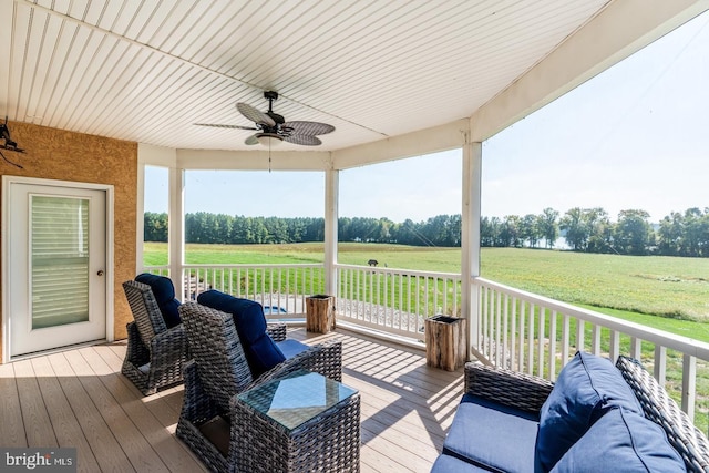 wooden terrace with a rural view, a yard, and ceiling fan