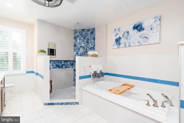 full bathroom featuring shower with separate bathtub, tile walls, vanity, toilet, and tile patterned floors