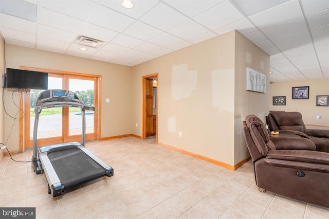 exercise room featuring light tile patterned floors and a drop ceiling