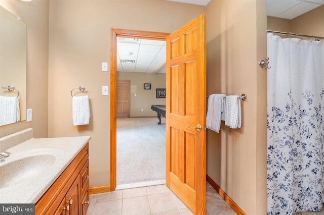 bathroom with vanity, tile patterned flooring, a shower with shower curtain, and a drop ceiling