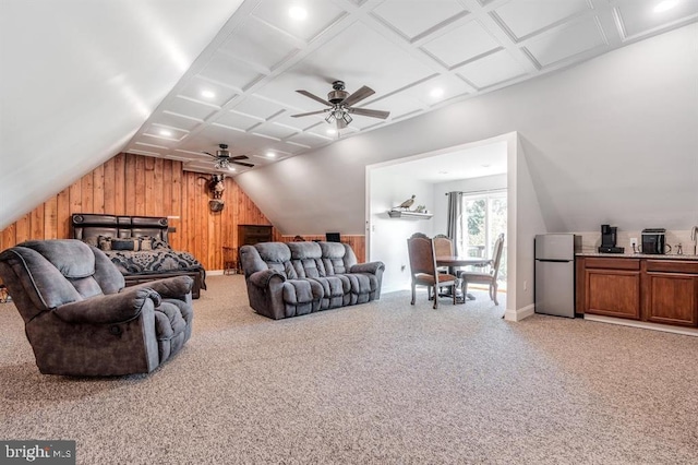 carpeted living room featuring coffered ceiling, wooden walls, ceiling fan, and vaulted ceiling