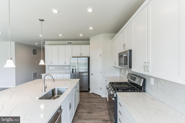 kitchen featuring white cabinetry, sink, hanging light fixtures, light stone counters, and stainless steel appliances