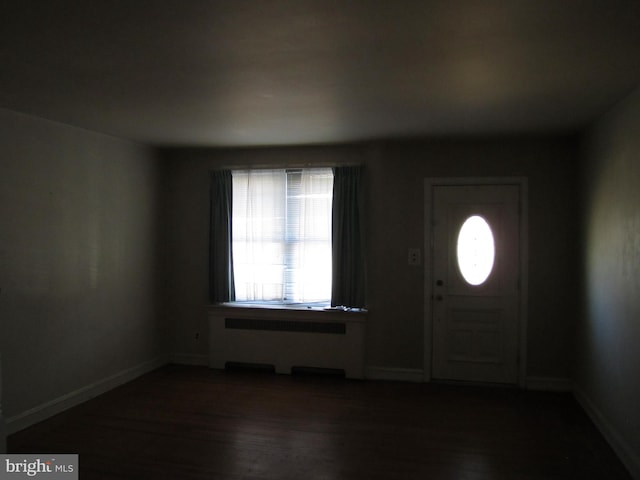 entrance foyer with radiator and dark wood-type flooring