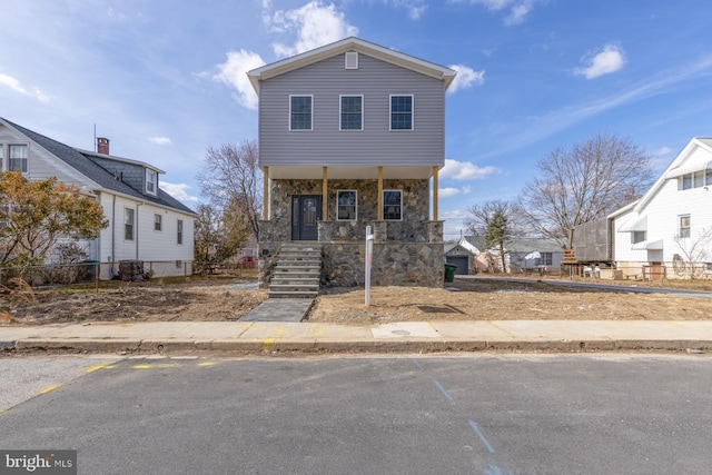 view of front of house with stone siding and covered porch