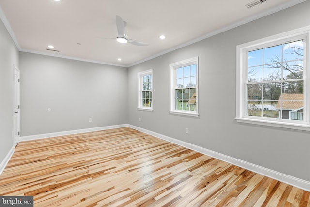 empty room with crown molding, baseboards, and light wood finished floors