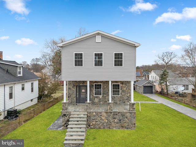 view of front of home with a front yard, a porch, an outbuilding, and stone siding