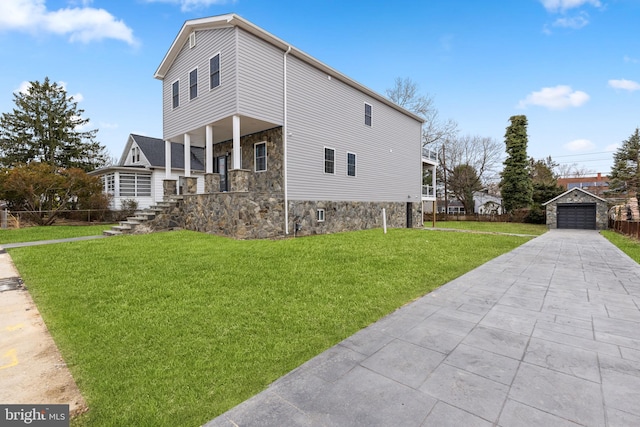 view of home's exterior with covered porch, an outdoor structure, a garage, stone siding, and a lawn