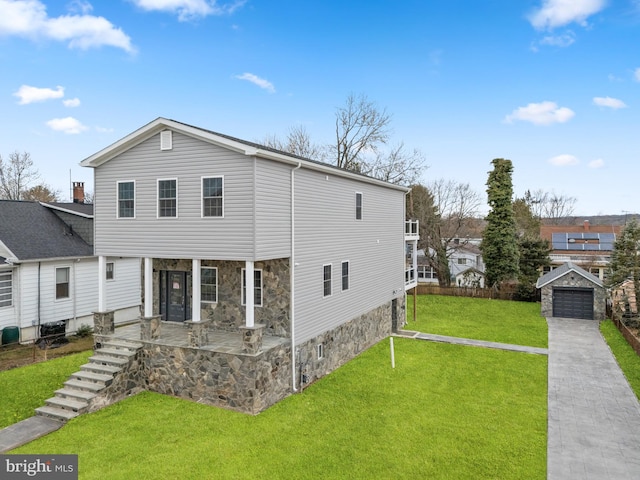 exterior space with an outbuilding, a lawn, stone siding, and a patio area