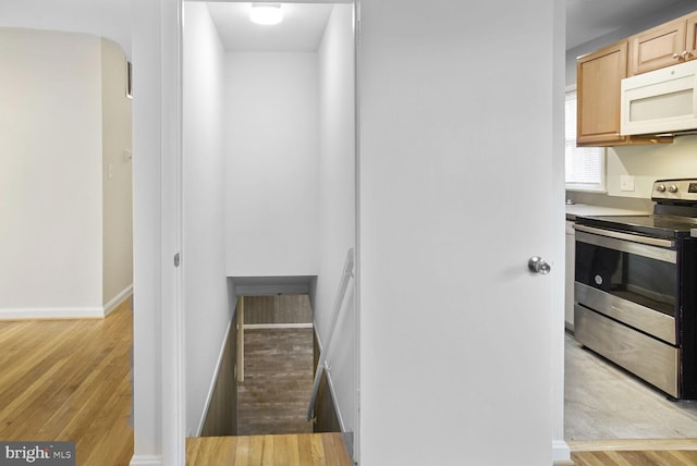 stairs featuring wood finished floors and baseboards