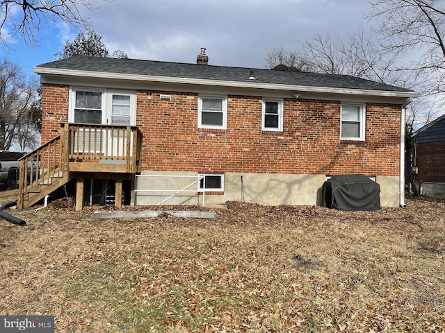 rear view of property with roof with shingles, a chimney, and brick siding