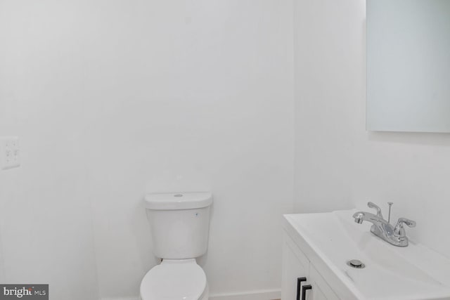 bathroom with vanity, toilet, and baseboards