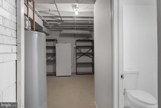 unfinished below grade area featuring concrete block wall and water heater