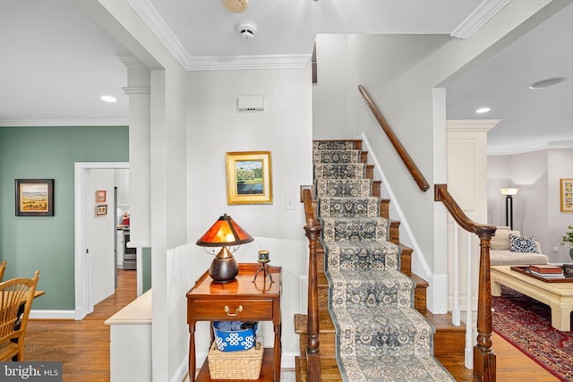 staircase with hardwood / wood-style flooring and ornamental molding