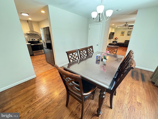 dining space featuring ceiling fan with notable chandelier and light hardwood / wood-style floors