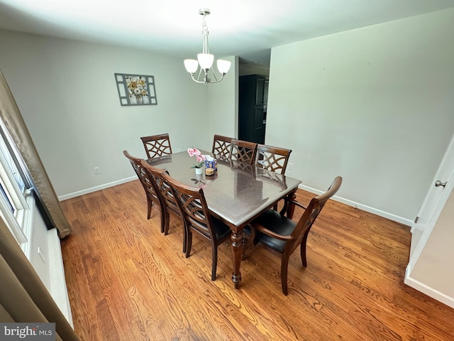 dining space featuring light hardwood / wood-style floors and a notable chandelier