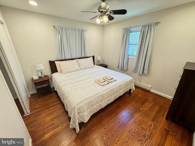 bedroom featuring a baseboard heating unit, dark wood-type flooring, and ceiling fan