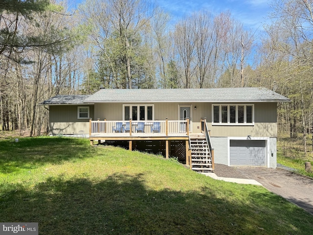 view of front of home with a garage, a deck, and a front lawn