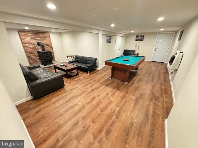 rec room featuring hardwood / wood-style floors, a wood stove, heating unit, and billiards