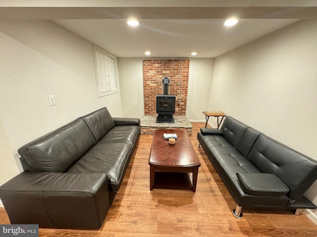 living room with a wood stove and light wood-type flooring