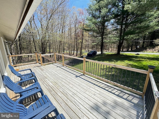 wooden terrace featuring a yard