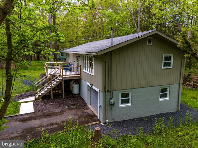 view of property exterior featuring a garage and a wooden deck