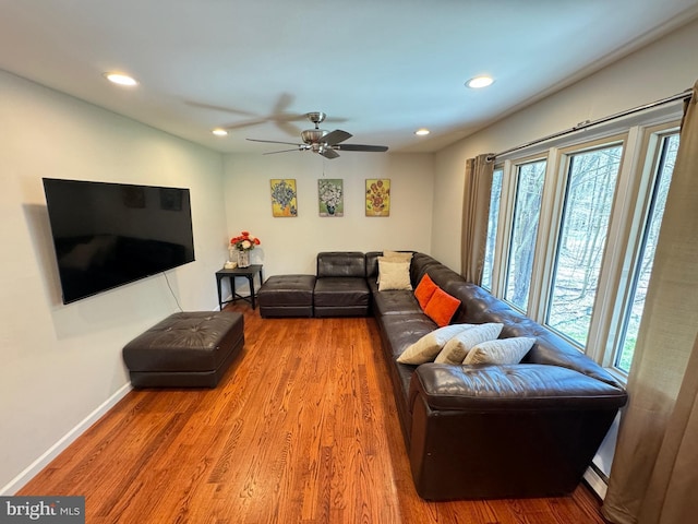 living room featuring a baseboard radiator, hardwood / wood-style floors, and ceiling fan