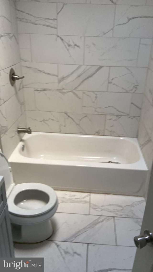 full bathroom with tiled shower / bath combo, vanity, and toilet