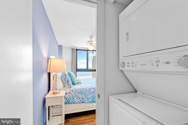 bedroom featuring stacked washer / drying machine and hardwood / wood-style floors