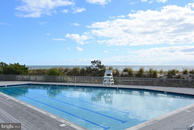 view of swimming pool featuring a water view