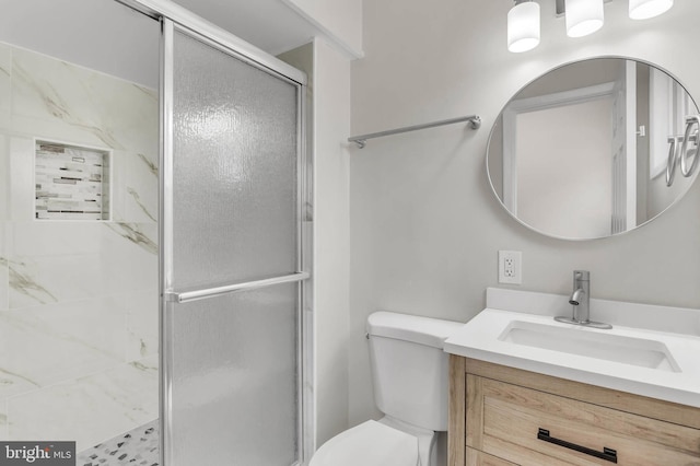 bathroom featuring vanity, an enclosed shower, and toilet