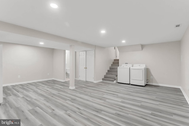 basement featuring washer and dryer and light wood-type flooring