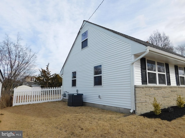 view of home's exterior with a yard and central AC