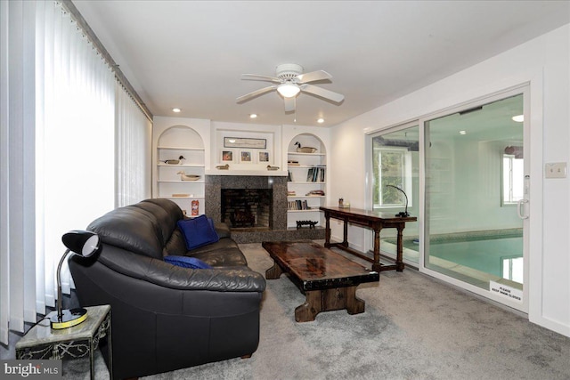 living room with ceiling fan, built in features, and carpet