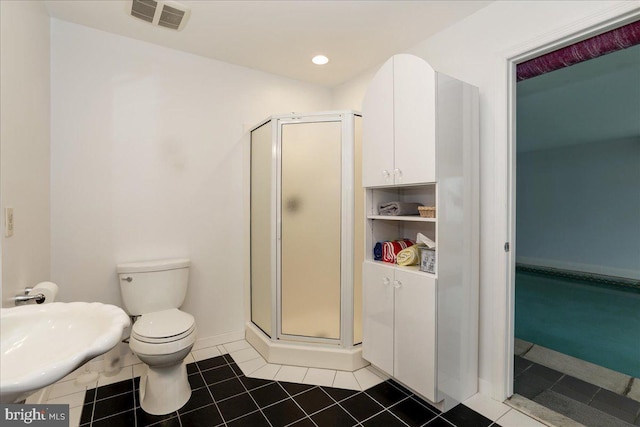 bathroom with tile patterned flooring, toilet, and walk in shower