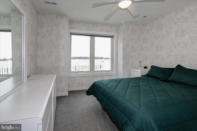 bedroom featuring a water view, carpet flooring, and ceiling fan