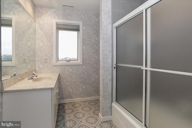 bathroom with vanity and shower / bath combination with glass door