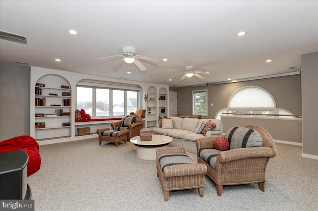 living room featuring carpet floors, built in features, and ceiling fan