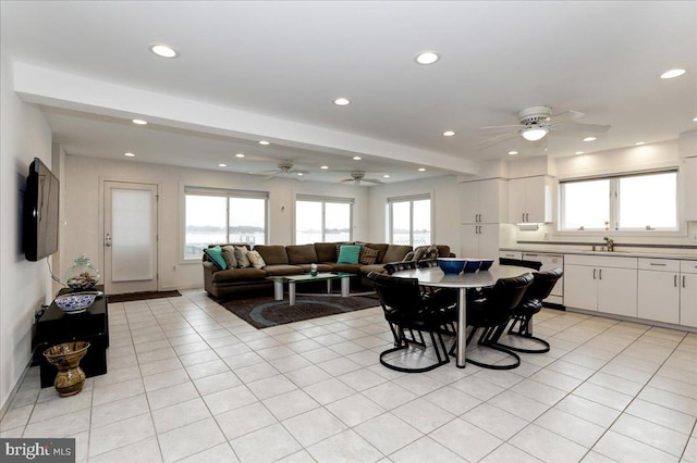 tiled dining room with ceiling fan, a healthy amount of sunlight, and sink