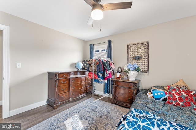 bedroom with ceiling fan, baseboards, and wood finished floors