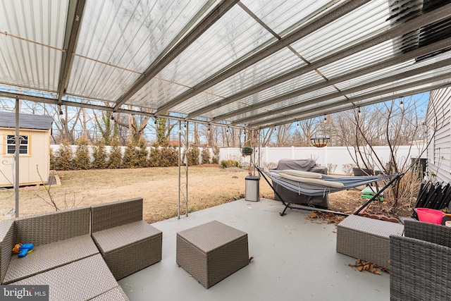 view of patio / terrace with an outdoor hangout area, a shed, an outdoor structure, and a fenced backyard