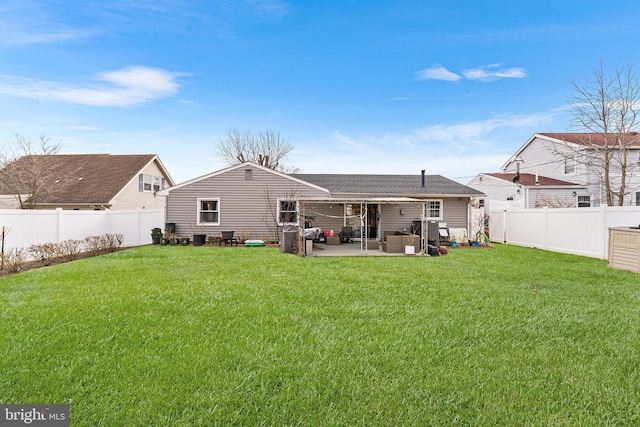 rear view of house with a patio, a lawn, and a fenced backyard