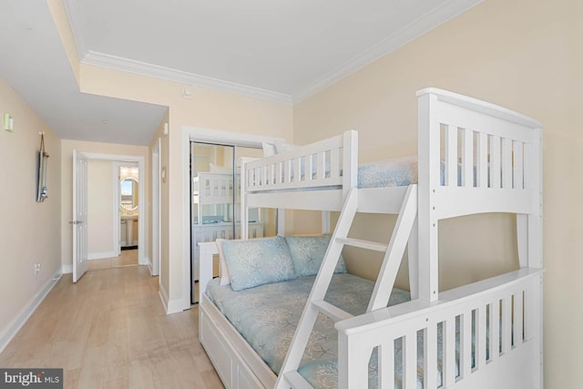 bedroom featuring crown molding, a closet, and light hardwood / wood-style flooring