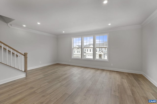 empty room with ornamental molding and light hardwood / wood-style flooring