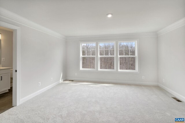 unfurnished room with ornamental molding and carpet flooring